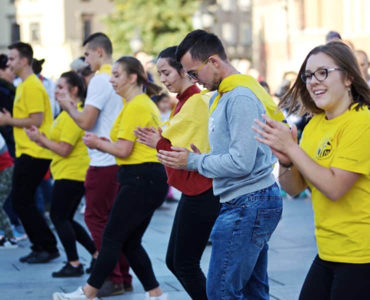 Group of people wearing yellow shirt dancing