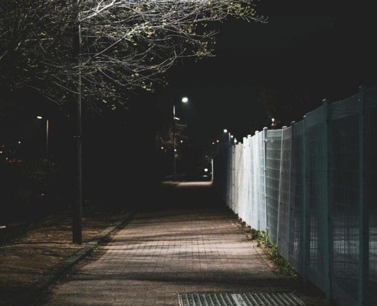 empty street at night with streetlights and shadows, representing nocturnal crime and quiet surveillance