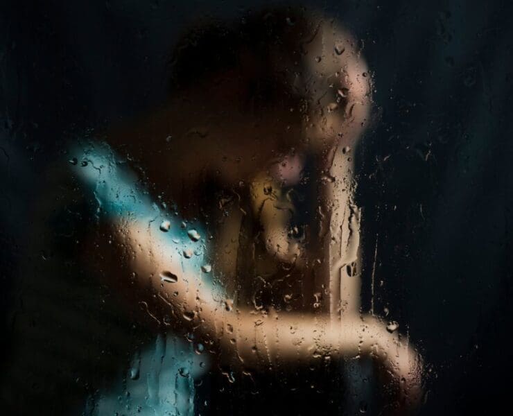 Post-incident background music with blurred figure behind rain-covered glass at night